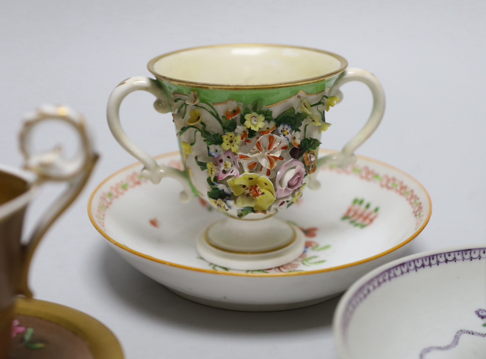 A group of early 19th century English porcelain cups and various saucers to include a Spode two handled chocolate cup and saucer (10)